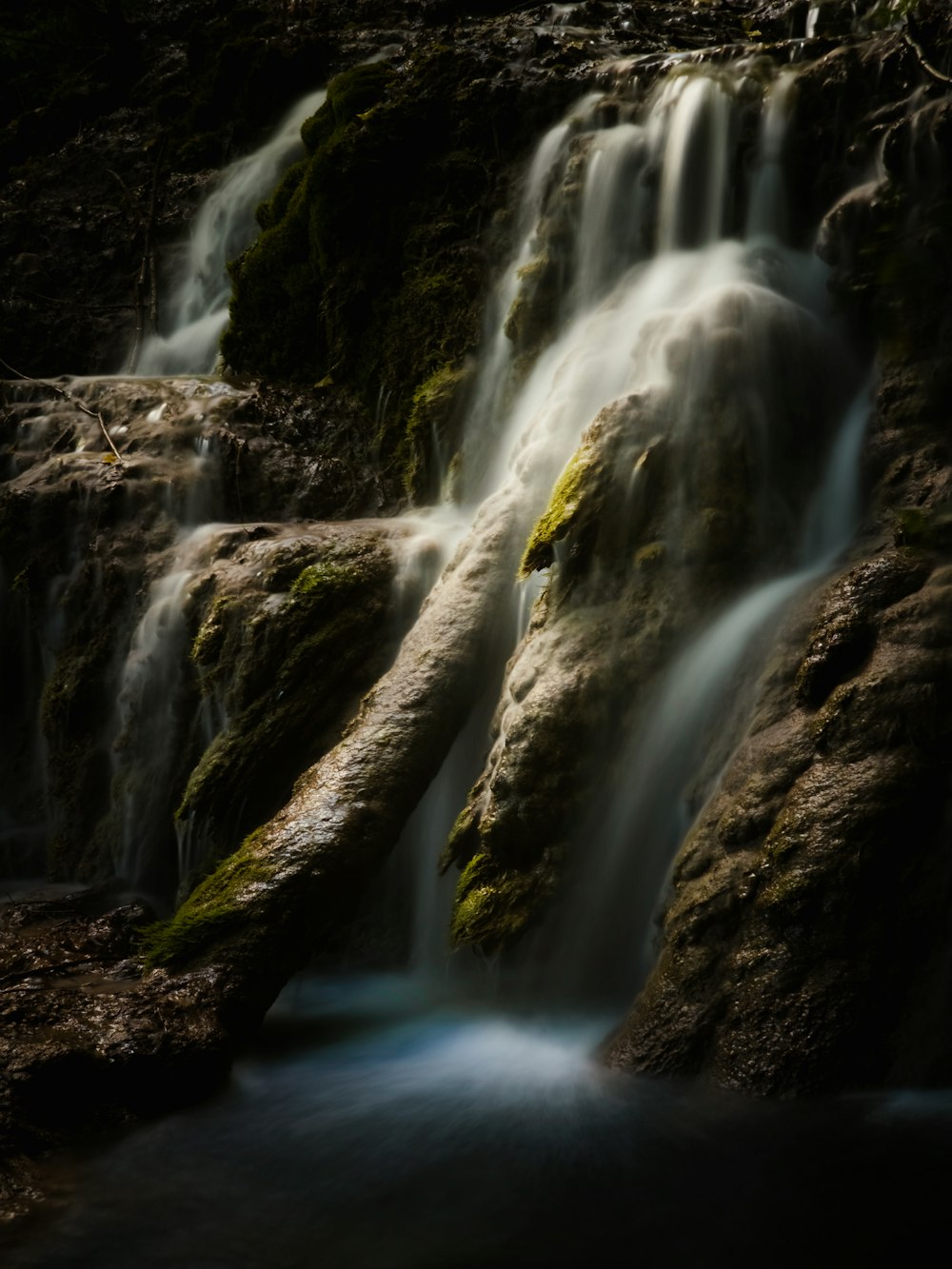 a small waterfall with moss growing on the rocks