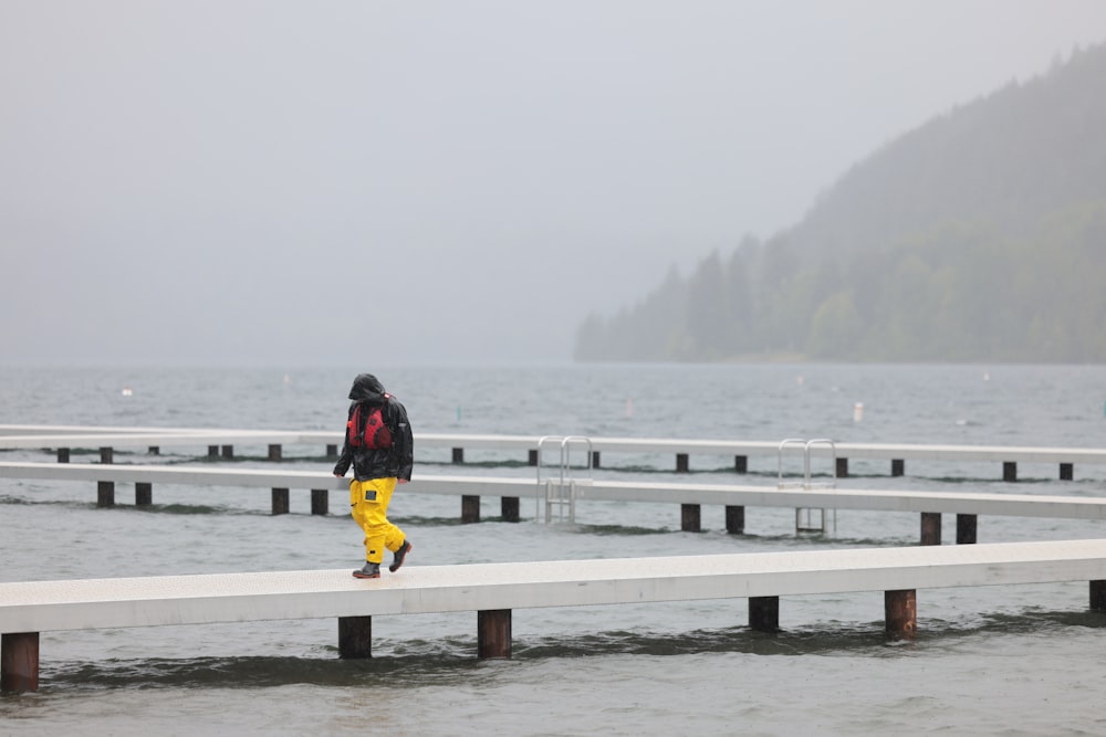 a person walking on a dock in the rain