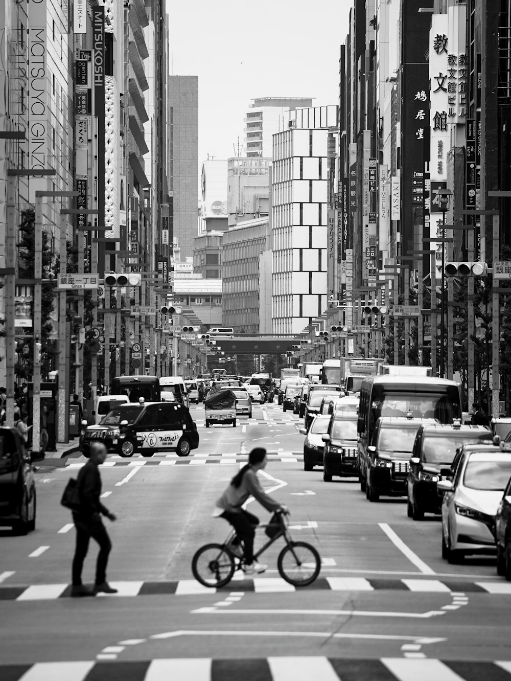 a man riding a bike down a street next to tall buildings