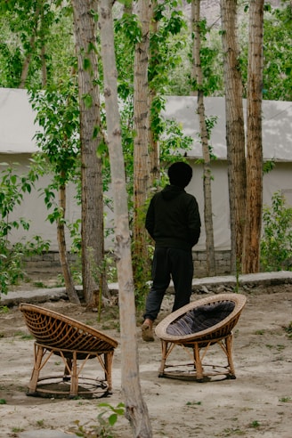 a man standing next to a bench in the woods