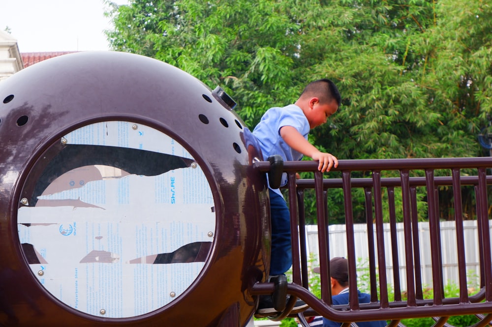 a young boy standing on top of a playground structure