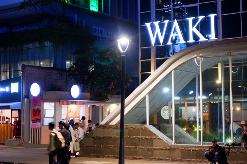 a group of people standing outside of a building at night