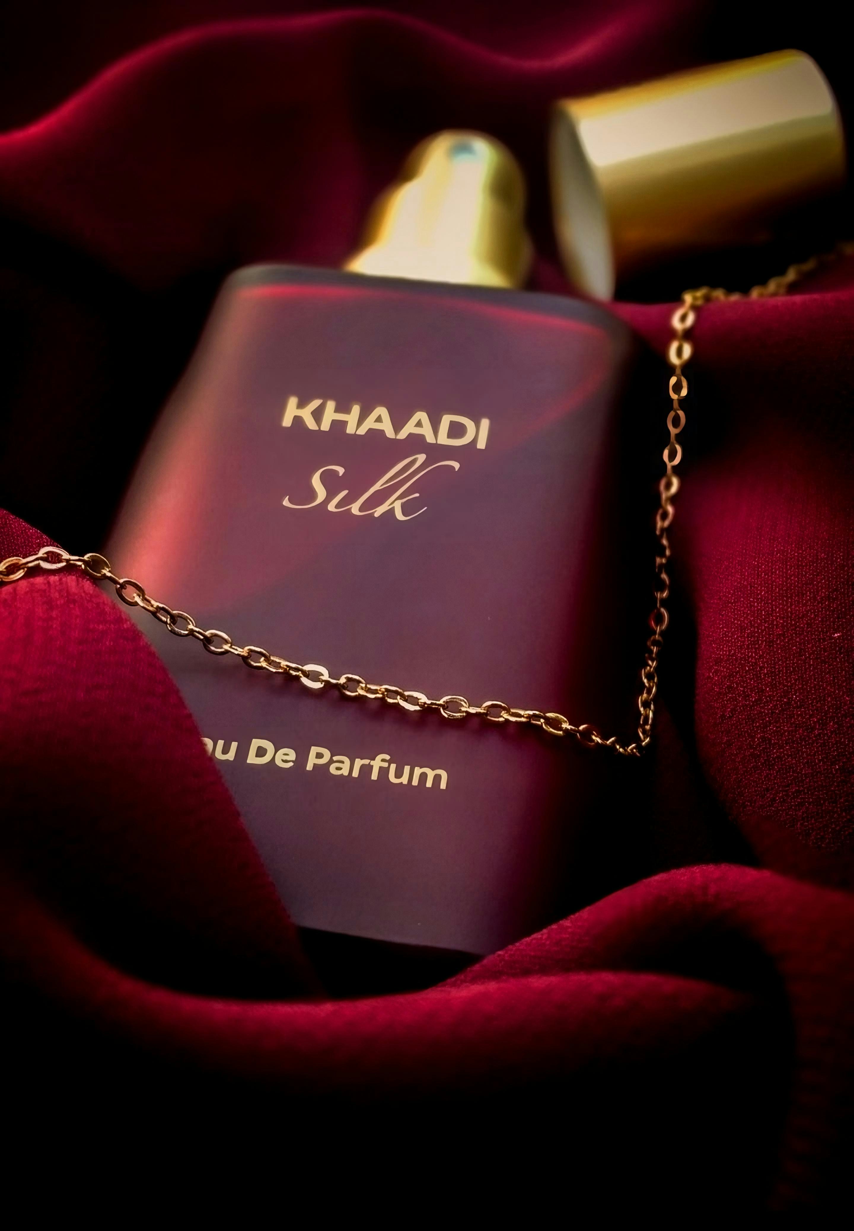 a bottle of perfume sitting on top of a red blanket