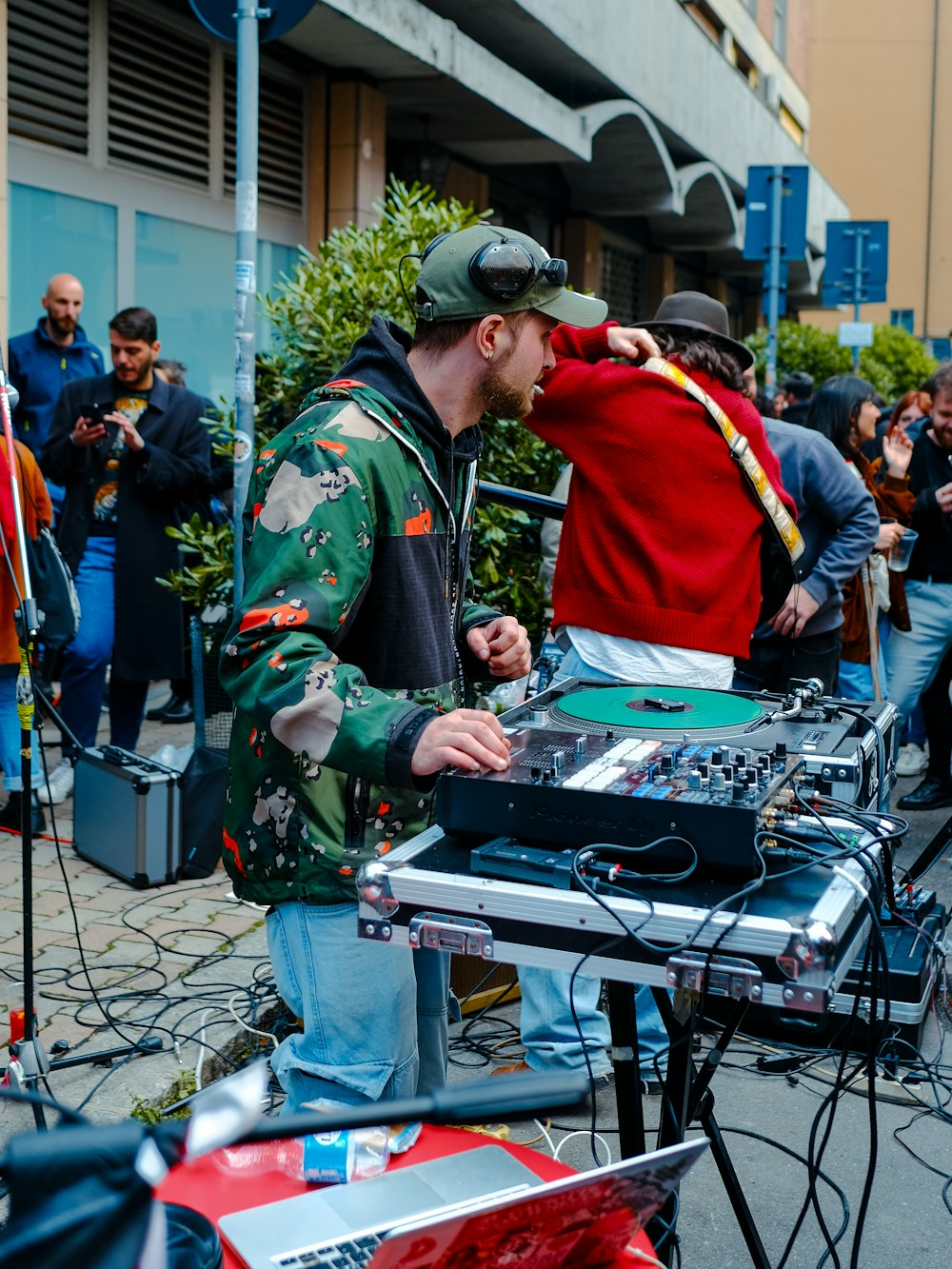 a man standing next to a dj set on top of a table