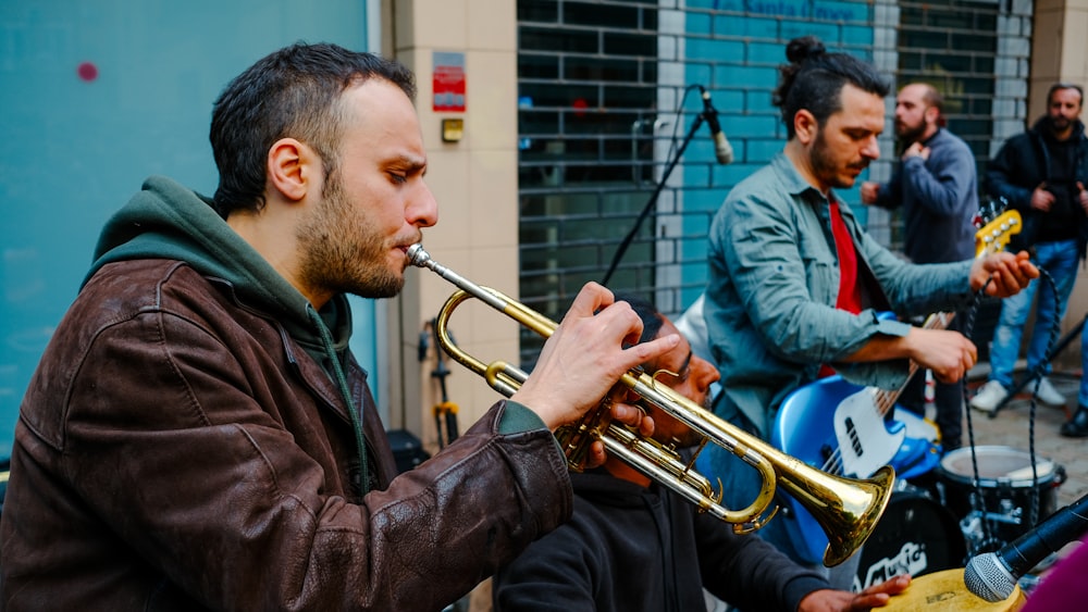 a man playing a trumpet in front of a group of people