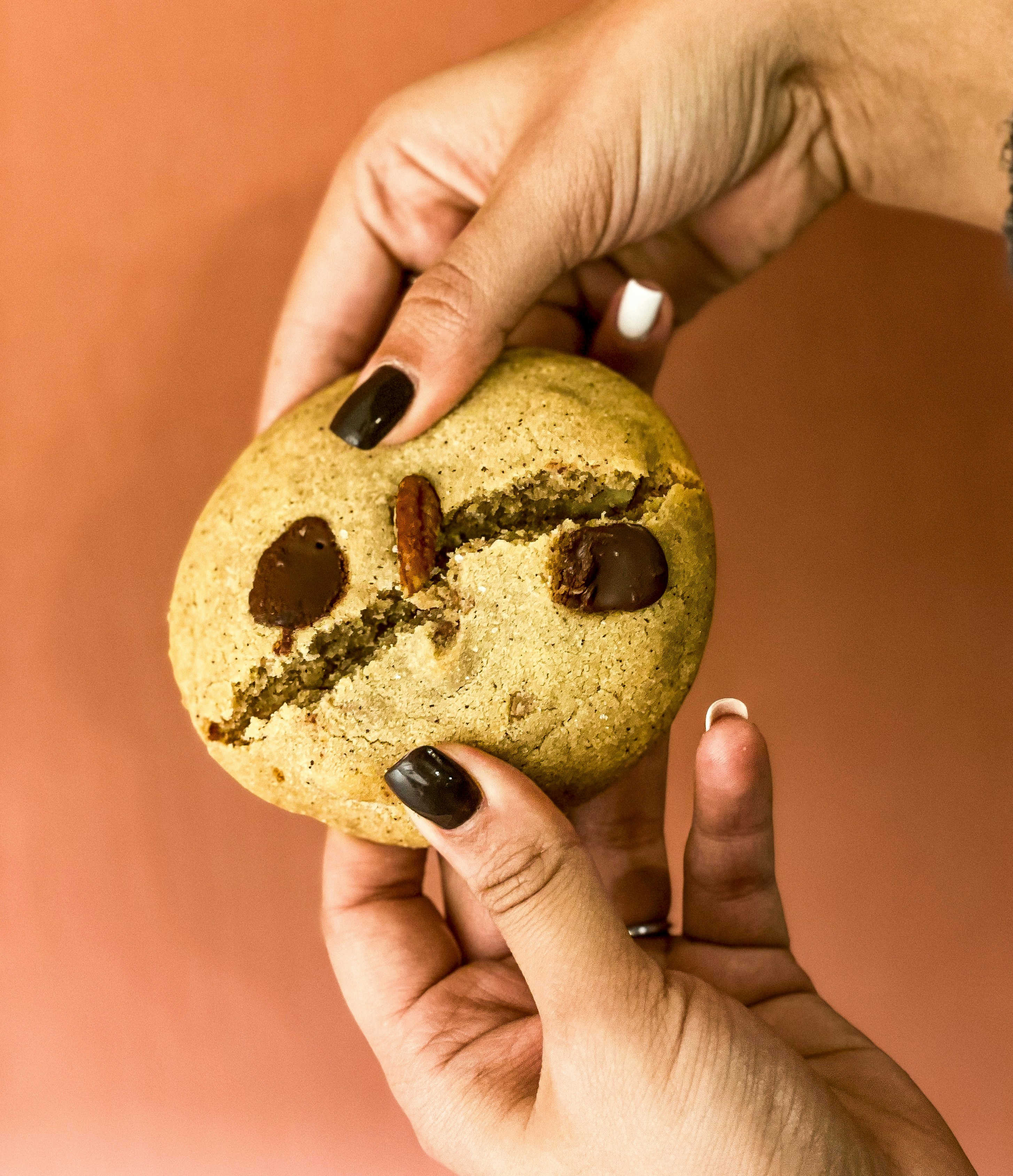a person holding a cookie with a smiley face on it