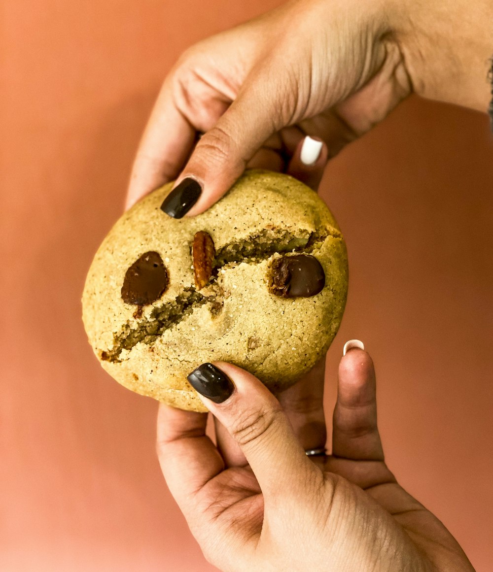 a person holding a cookie with a smiley face on it