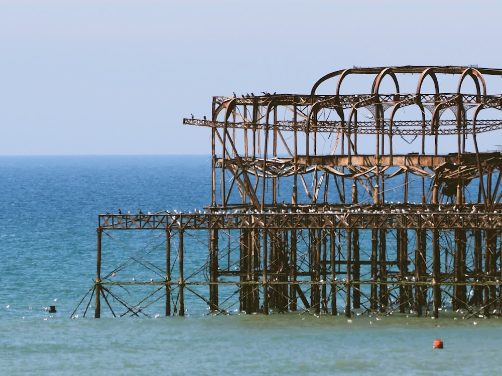 a rusted structure in the water near a beach