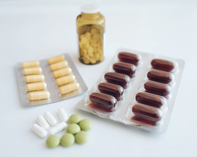 a table topped with pills and a bottle of pills