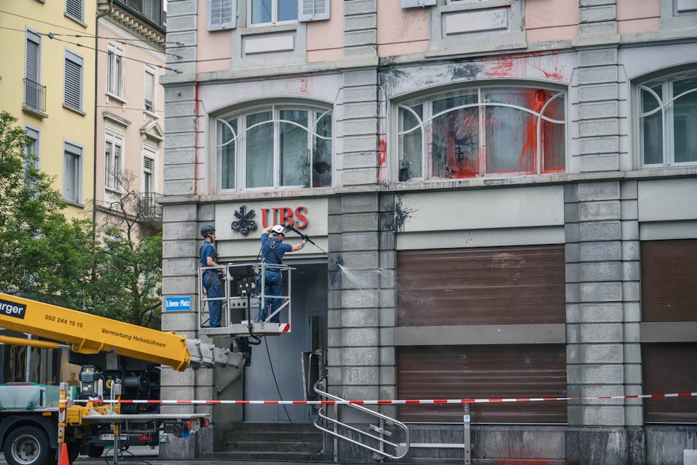 a man standing on a lift in front of a building