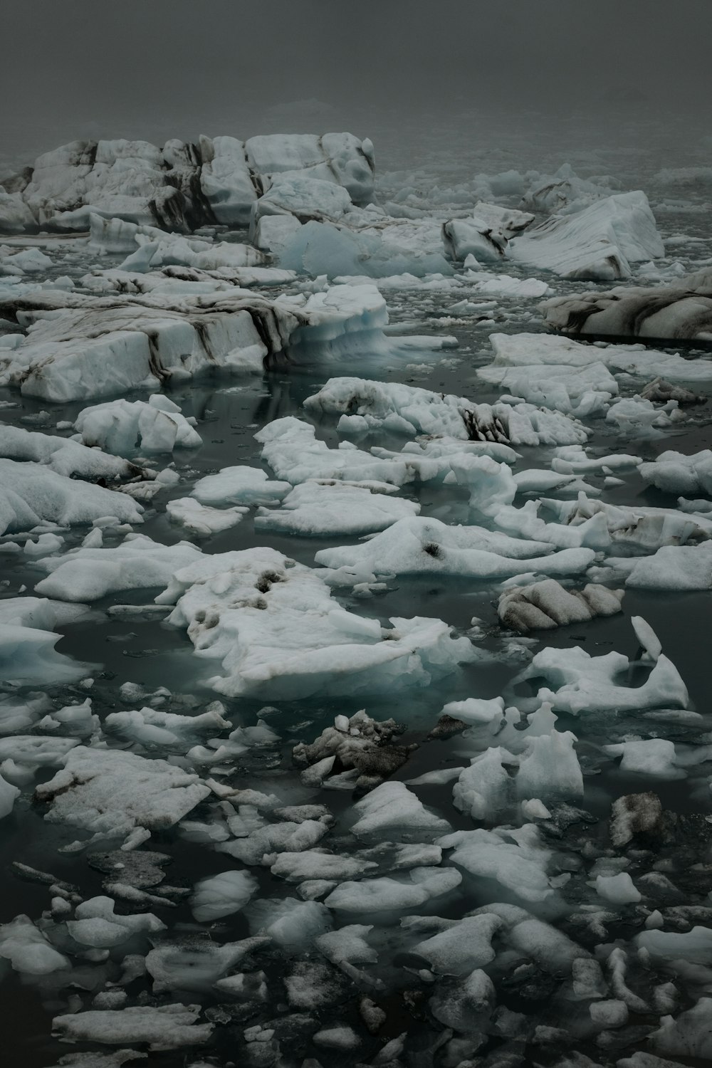 a group of icebergs floating on top of a body of water