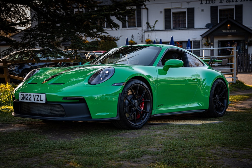 a green sports car parked in front of a house