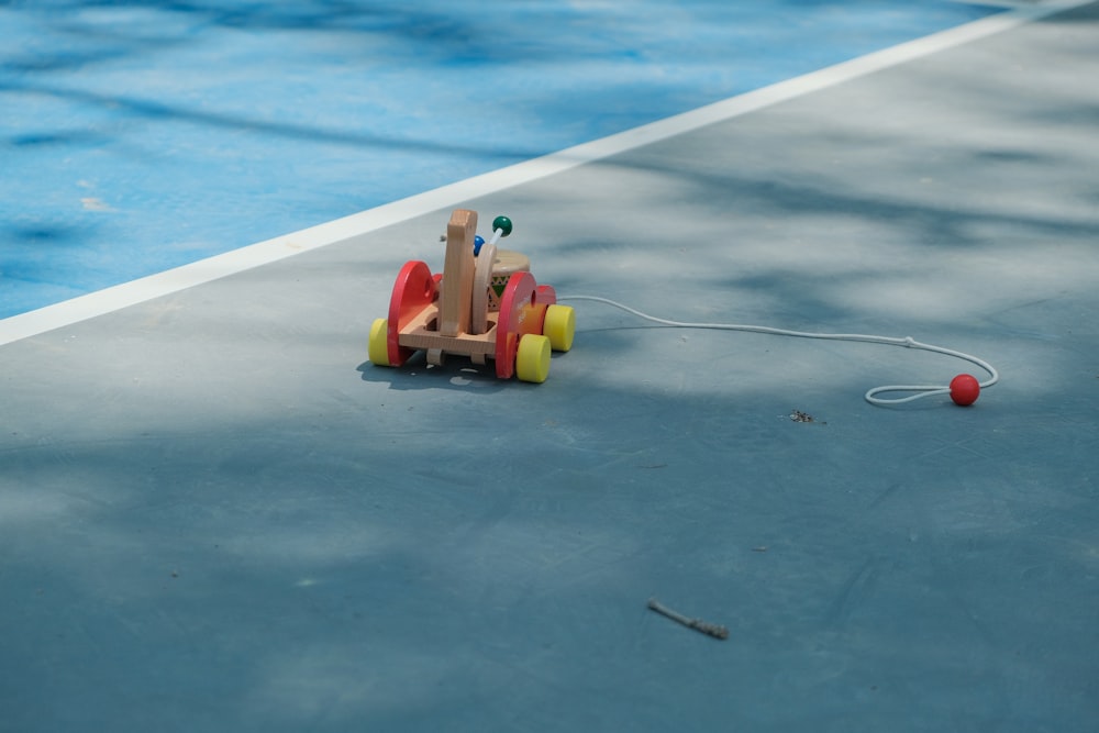 a wooden toy car on a tennis court