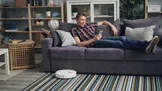 a man laying on a couch with a remote control