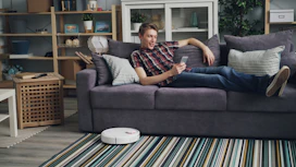 a man laying on a couch with a remote control