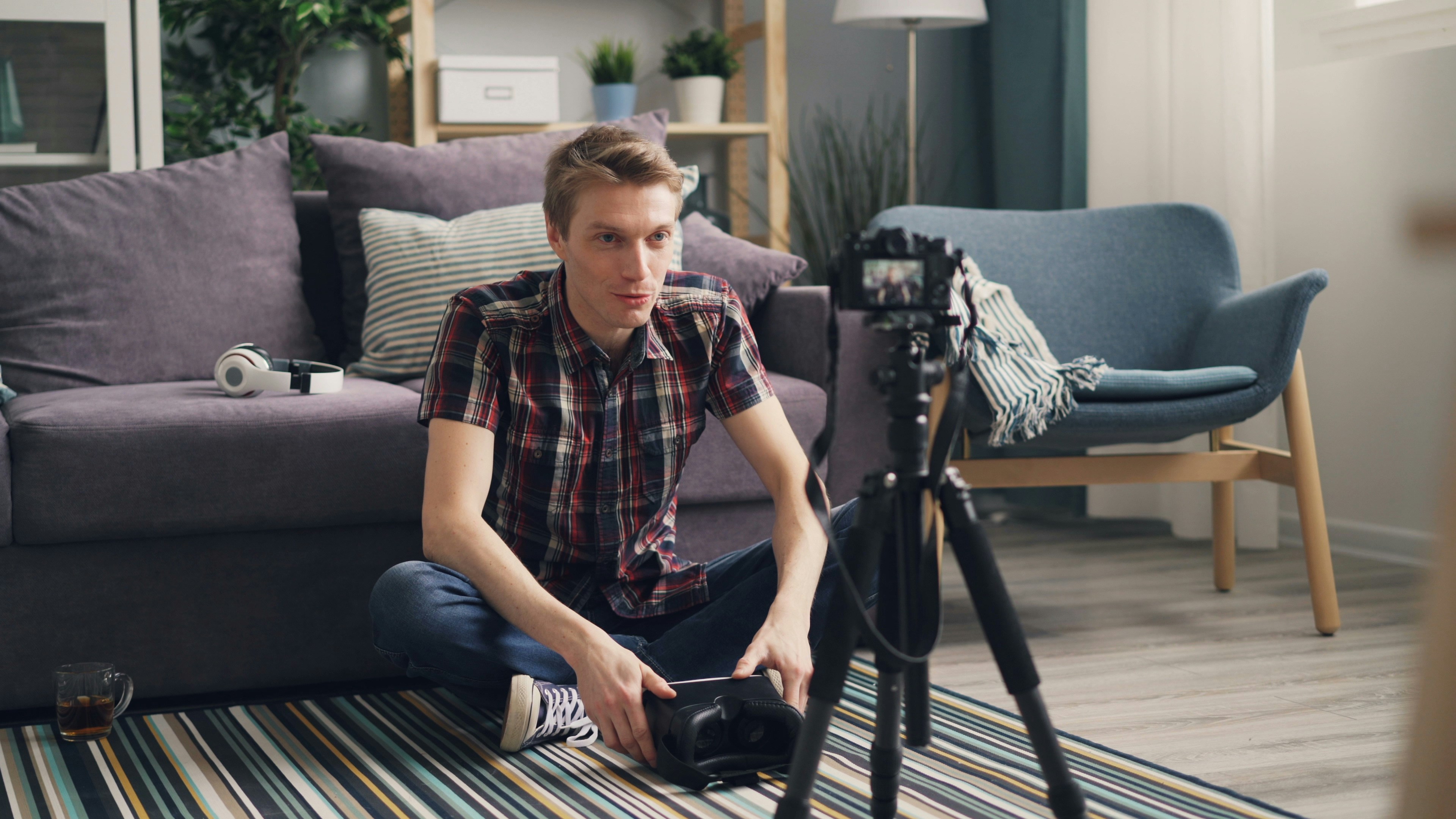 a man sitting on the floor in front of a camera