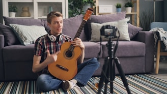 a man sitting on the floor with a guitar