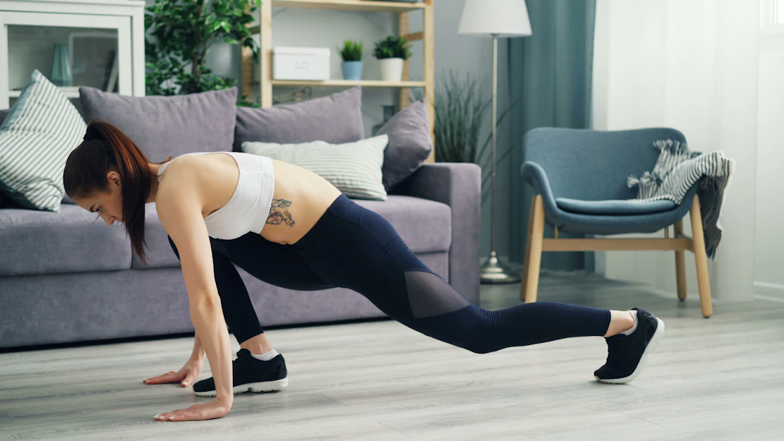 a woman is doing a push up in a living room