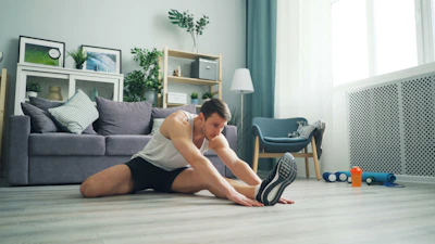 a man sitting on the floor with a pair of shoes