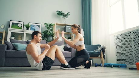 a man and woman sitting on the floor in front of a couch