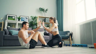 a man and woman sitting on the floor in front of a couch