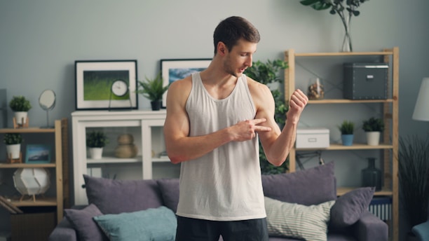 a man standing in a living room holding something in his hand