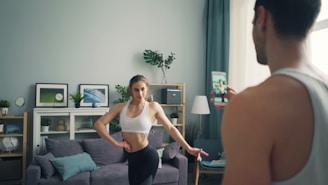 a woman standing in front of a man in a living room