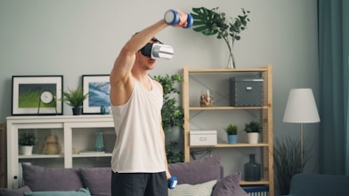 a man in a living room holding a pair of virtual glasses