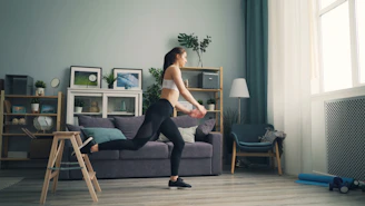 a woman in a white top and black leggings in a living room