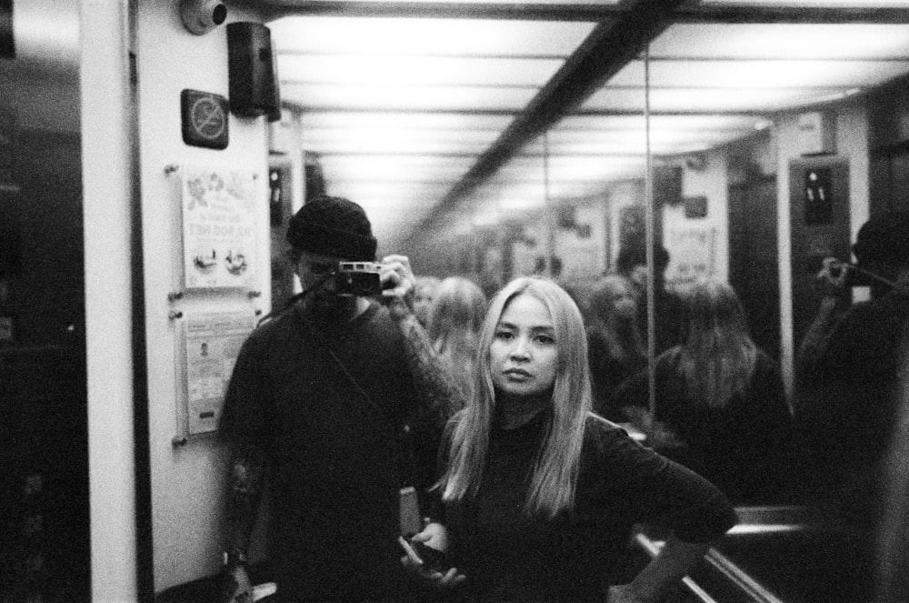 a woman standing next to a man on a subway