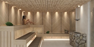 a woman sitting in a wooden sauna