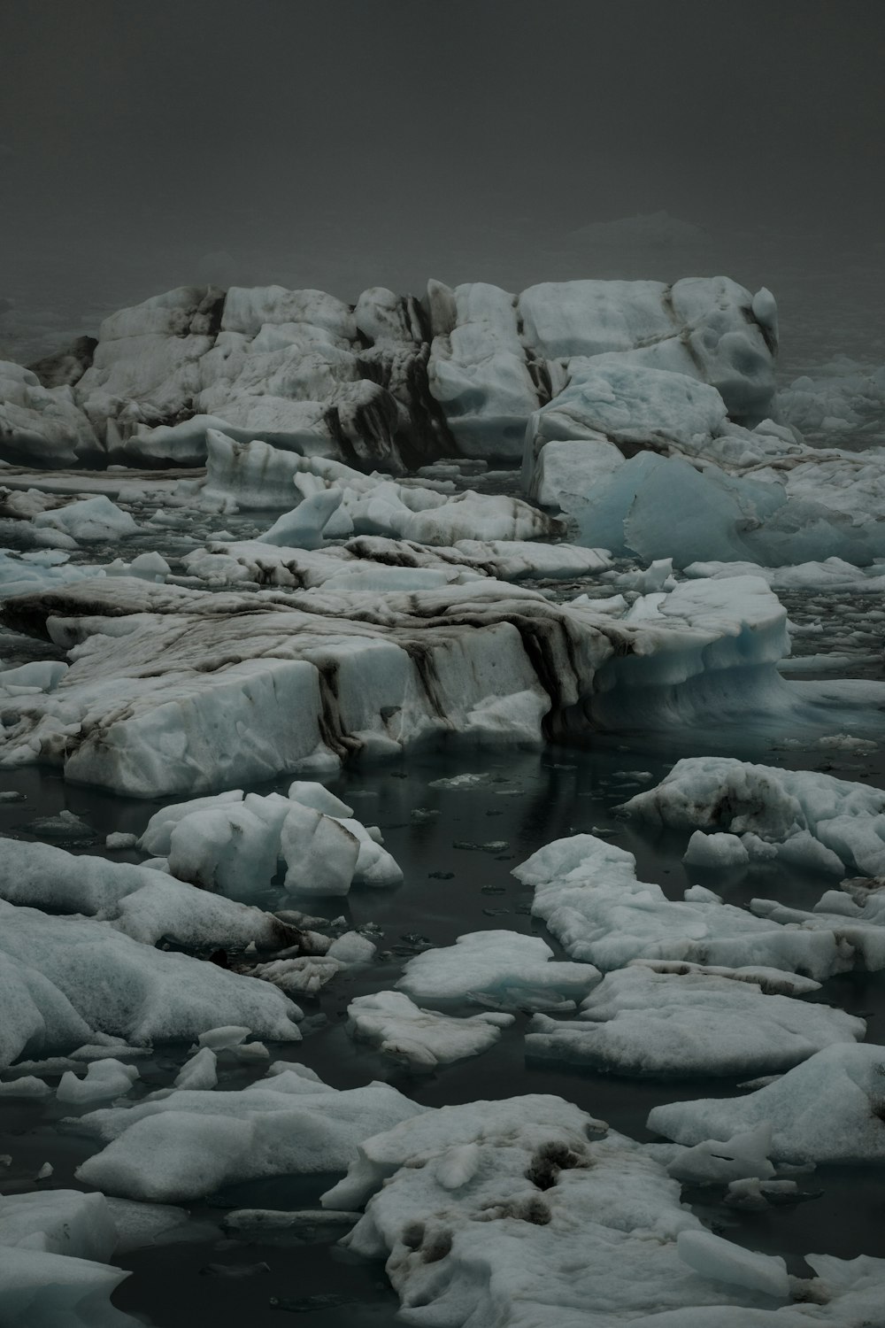 a group of icebergs floating on top of a body of water