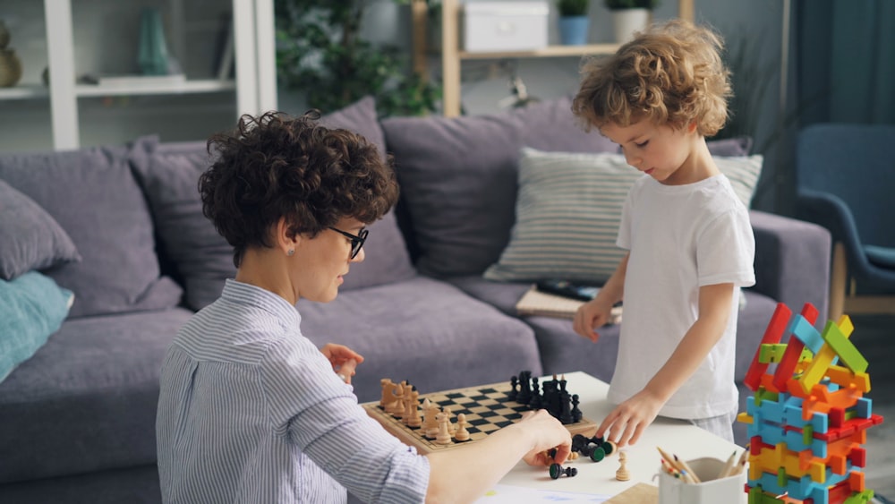 a woman playing a game of chess with a child