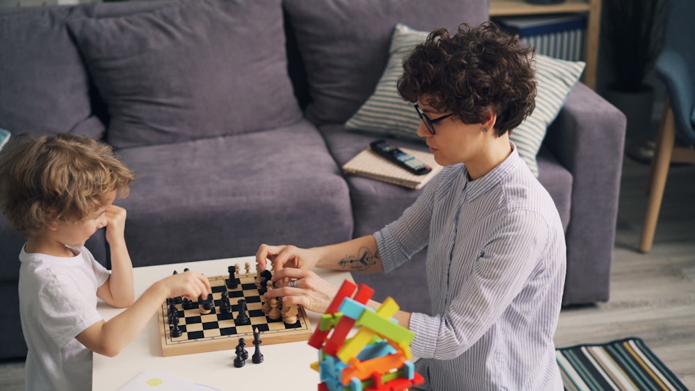 a boy and a girl playing a game of chess