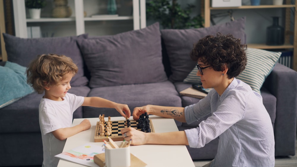 a boy and a boy playing chess on a coffee table