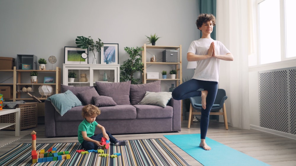 a man and a child doing yoga in a living room