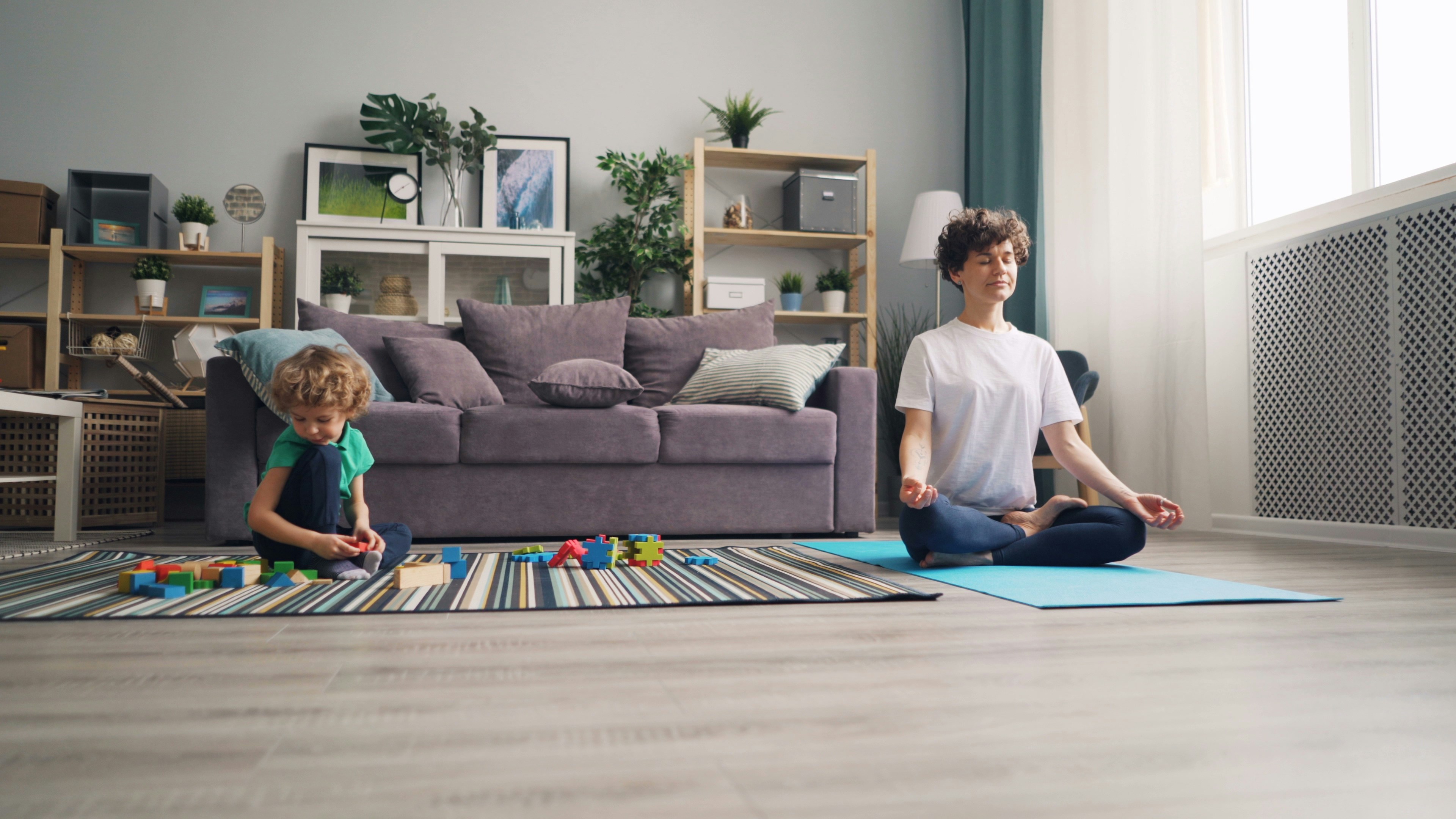 a woman and a child sitting on a rug in a living room