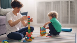 a man and a child playing with blocks on the floor