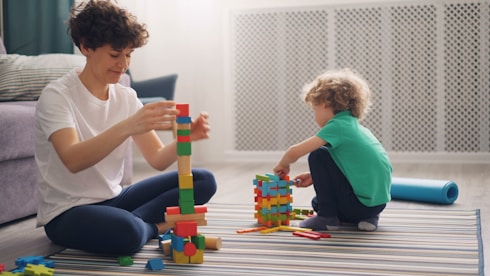a man and a child playing with blocks on the floor