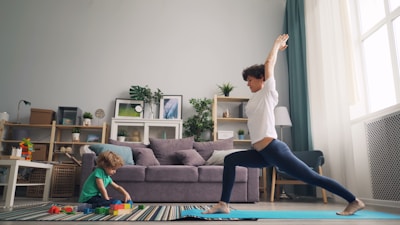 a woman and a child doing yoga in a living room