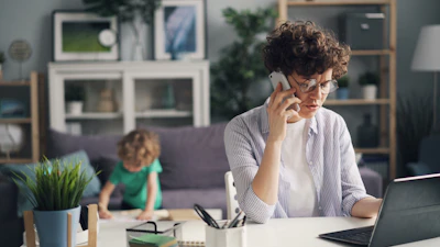a woman sitting at a table talking on a cell phone