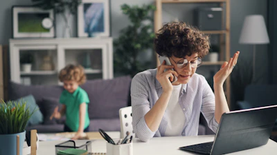 a woman sitting at a table talking on a cell phone