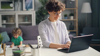 a woman sitting at a table using a laptop computer