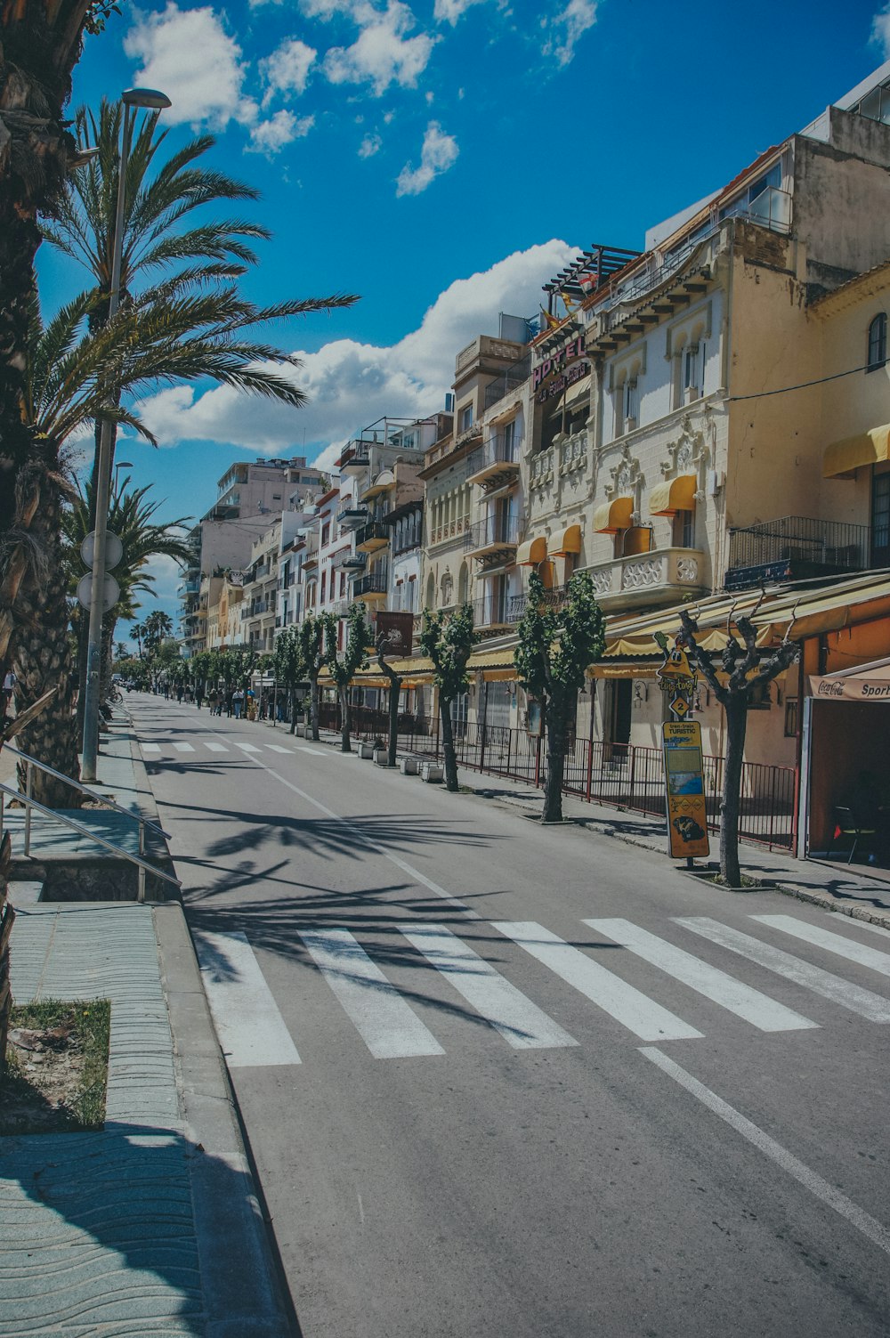 a city street lined with tall buildings and palm trees