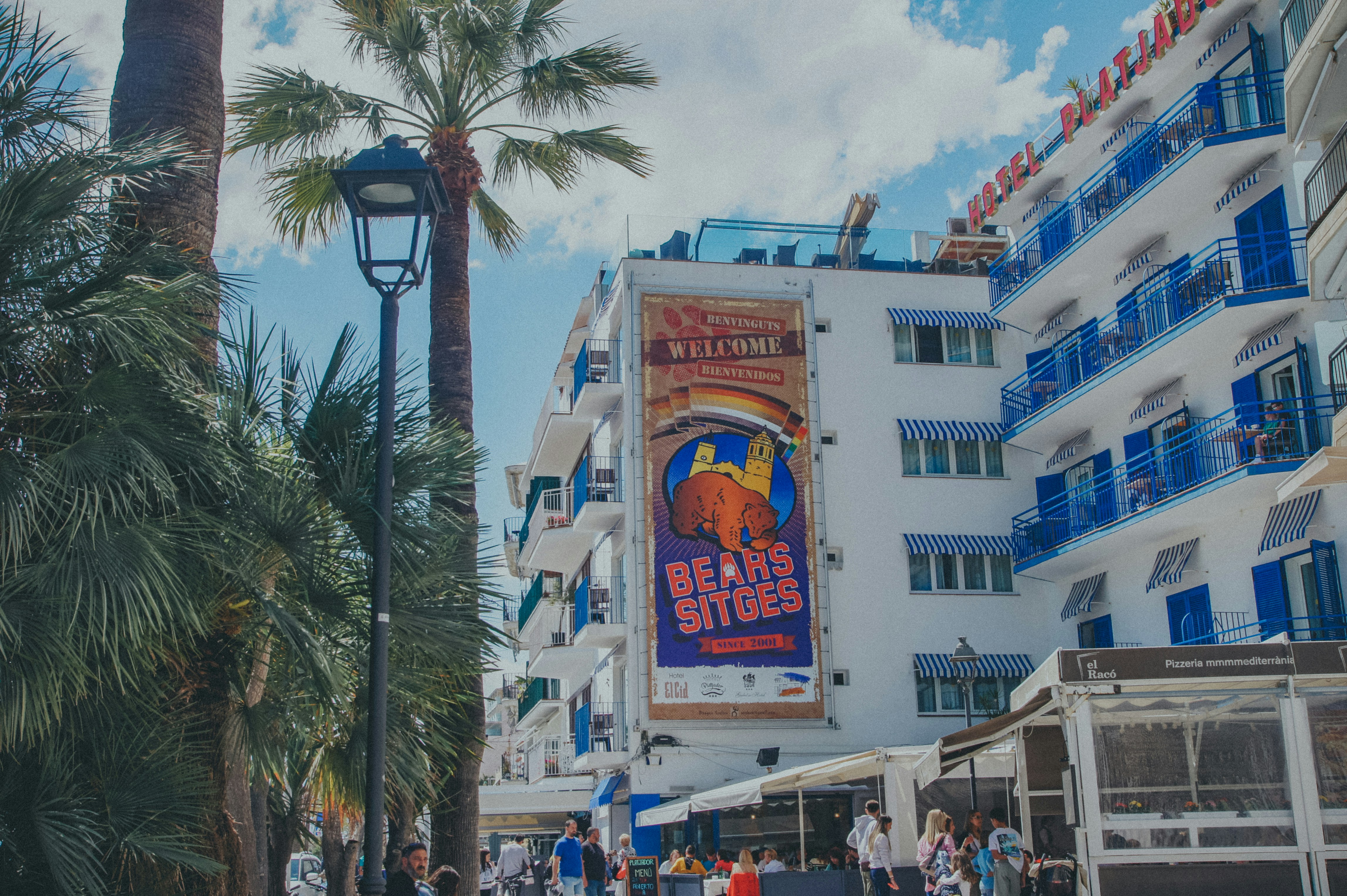 a group of people walking down a street next to tall buildings