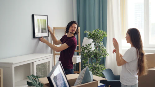 Two people unpacking in a new home surrounded by moving boxes