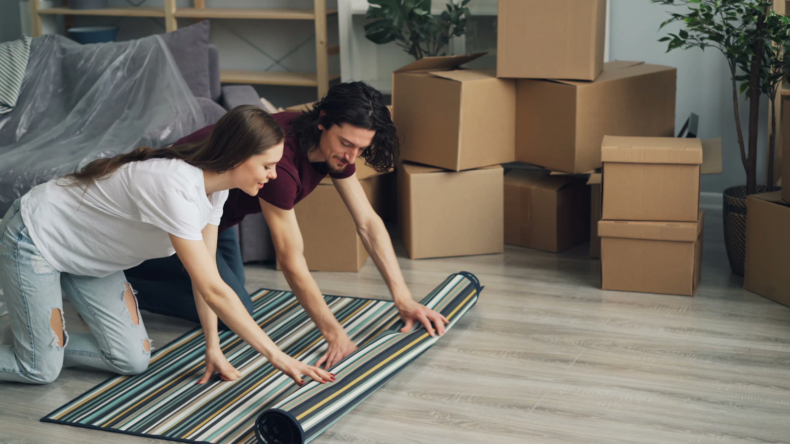A couple resting among moving boxes in their new home