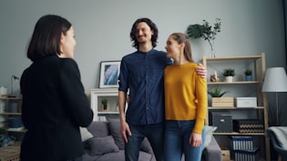 a man and two women standing in a living room