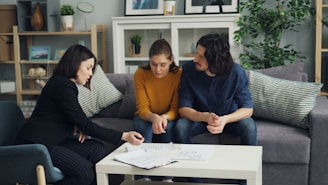 three women sitting on a couch talking to each other