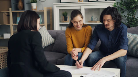 Home buyers reviewing real estate paperwork with their broker